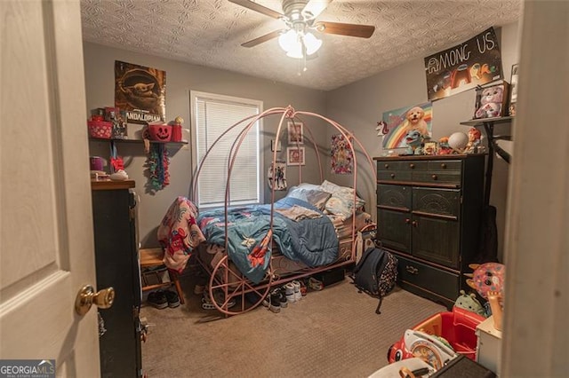 carpeted bedroom with ceiling fan and a textured ceiling