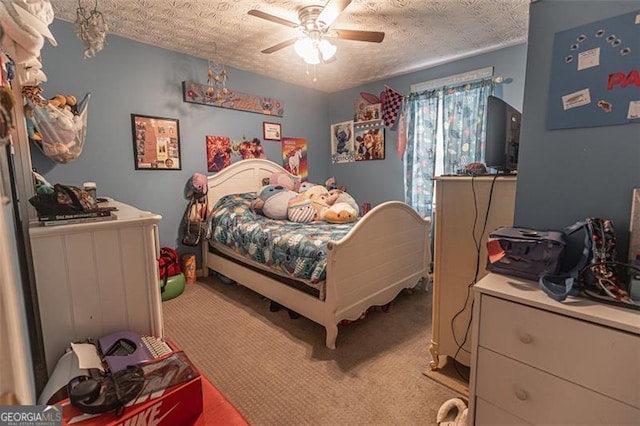 bedroom with ceiling fan, carpet, and a textured ceiling