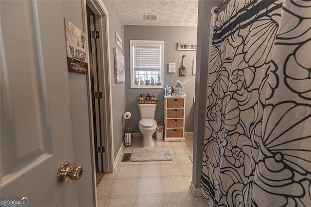 bathroom featuring a textured ceiling and toilet