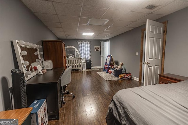 bedroom featuring a paneled ceiling and dark hardwood / wood-style floors