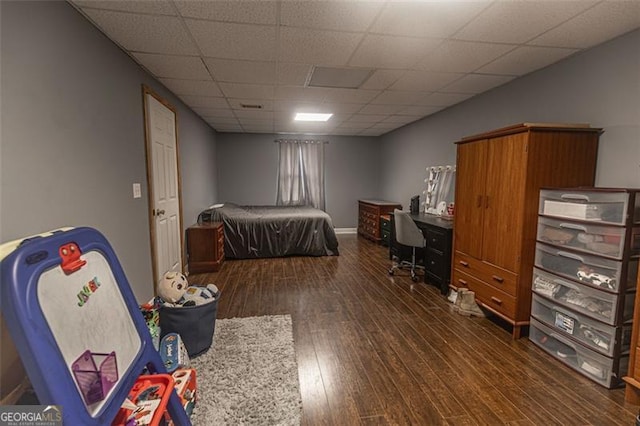 bedroom with dark hardwood / wood-style floors and a drop ceiling