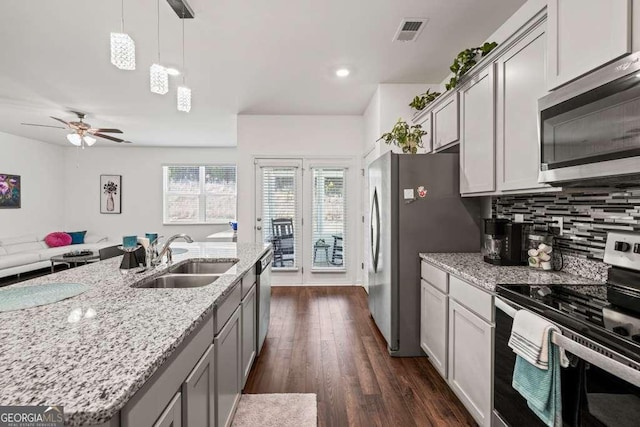 kitchen featuring gray cabinetry, sink, light stone counters, and appliances with stainless steel finishes