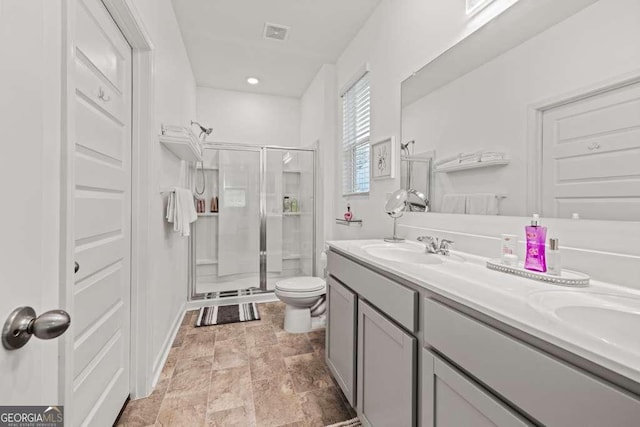 bathroom featuring vanity, toilet, and a shower with shower door