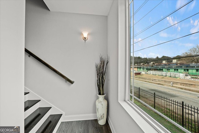 staircase featuring hardwood / wood-style flooring and a healthy amount of sunlight