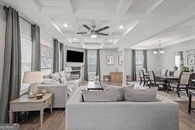 living room with ceiling fan with notable chandelier, coffered ceiling, hardwood / wood-style floors, and beam ceiling