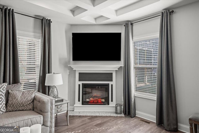 living room featuring hardwood / wood-style flooring, coffered ceiling, and beamed ceiling