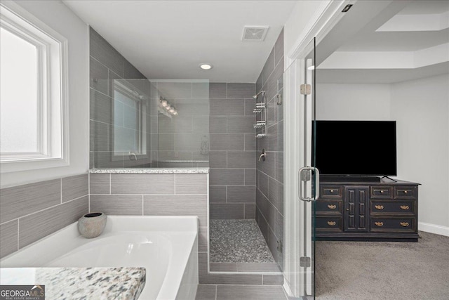 bathroom featuring shower with separate bathtub