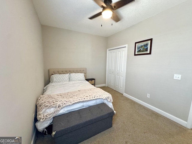 carpeted bedroom featuring ceiling fan, a closet, and a textured ceiling