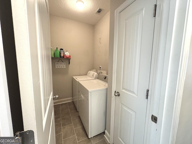 laundry area featuring washing machine and dryer and a textured ceiling