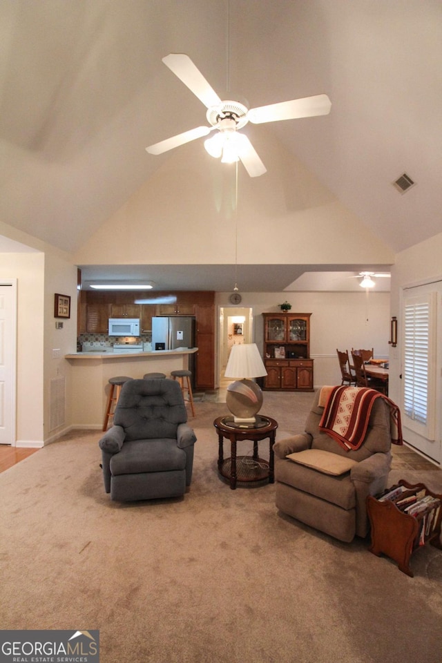 living room with high vaulted ceiling, light carpet, and ceiling fan