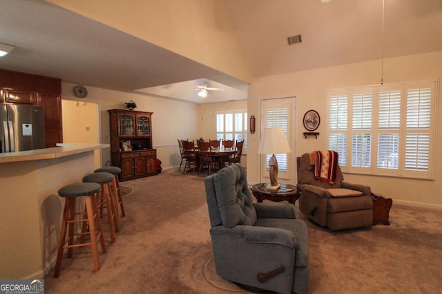 carpeted living room featuring ceiling fan and vaulted ceiling