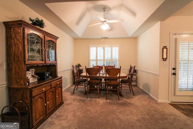 carpeted dining room featuring ceiling fan, lofted ceiling, plenty of natural light, and a tray ceiling