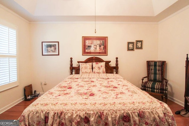 bedroom featuring ornamental molding, dark hardwood / wood-style floors, and a raised ceiling