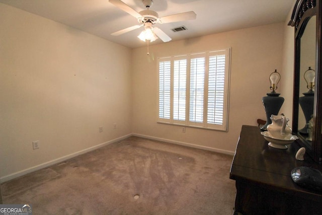 carpeted office space featuring ceiling fan