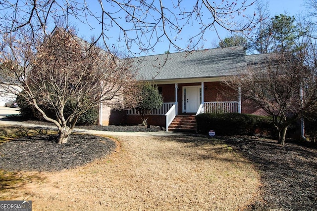 ranch-style house featuring a porch and a front yard