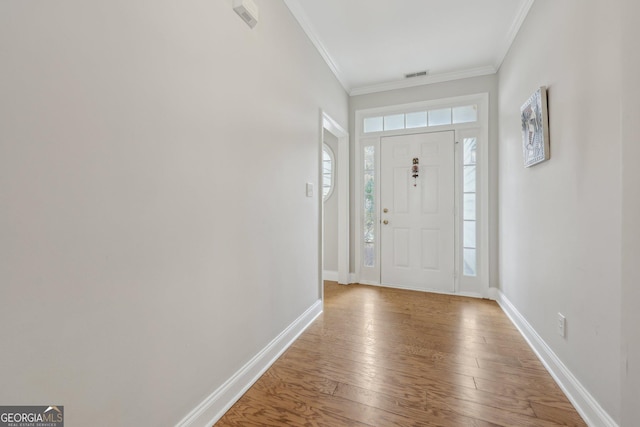 foyer entrance featuring crown molding and hardwood / wood-style floors