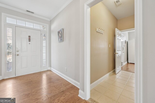 entrance foyer with ornamental molding and hardwood / wood-style floors