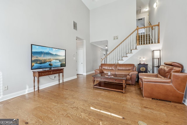 living room featuring a high ceiling and light wood-type flooring