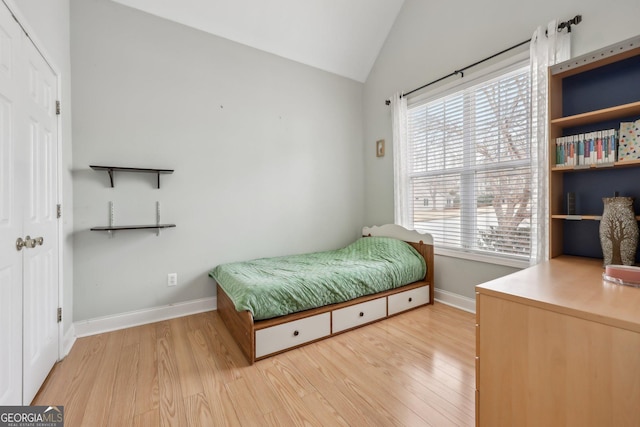 bedroom featuring vaulted ceiling and light wood-type flooring