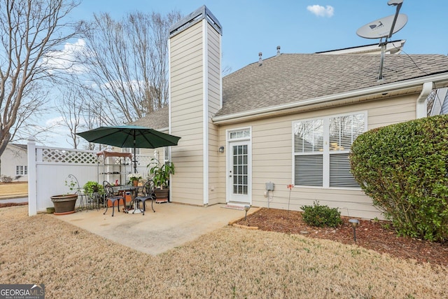 rear view of house featuring a lawn and a patio