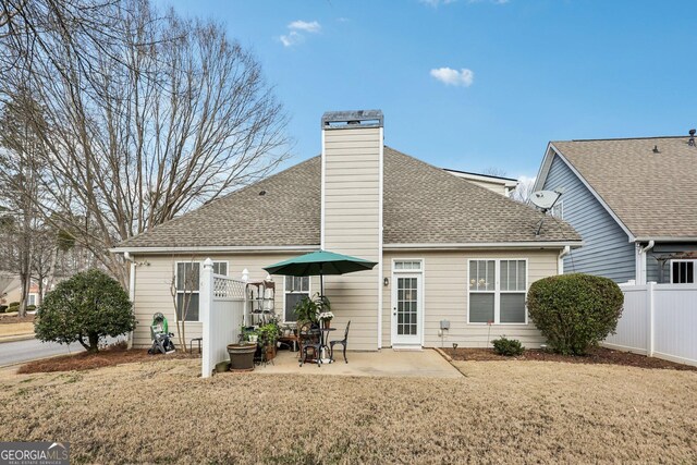 rear view of house featuring a lawn and a patio