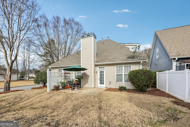 back of house with a lawn and a patio