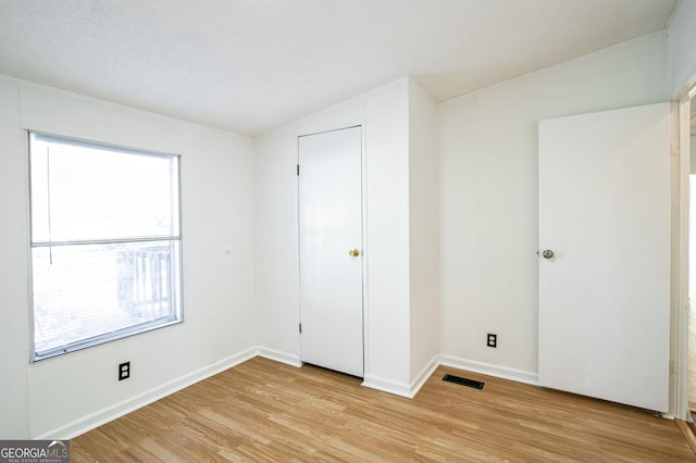 unfurnished bedroom featuring light hardwood / wood-style floors and a textured ceiling