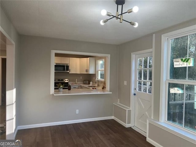 kitchen with stainless steel appliances, white cabinetry, sink, and dark wood-type flooring