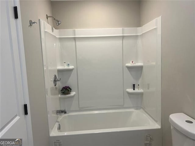 bathroom featuring shower / tub combination and toilet