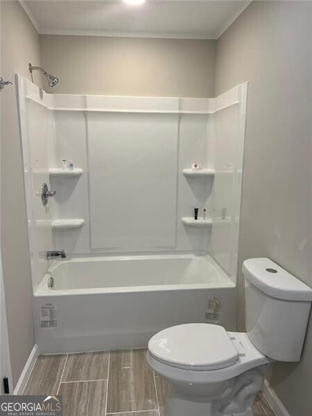 bathroom featuring washtub / shower combination and toilet