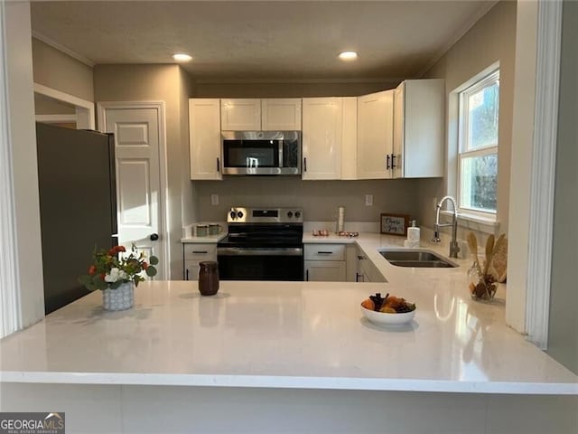 kitchen featuring sink, stainless steel appliances, kitchen peninsula, and white cabinets