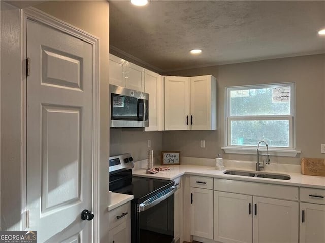 kitchen with sink, a textured ceiling, white cabinets, and appliances with stainless steel finishes