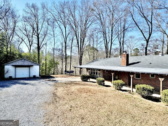 view of side of home with an outbuilding, a garage, a lawn, and a porch