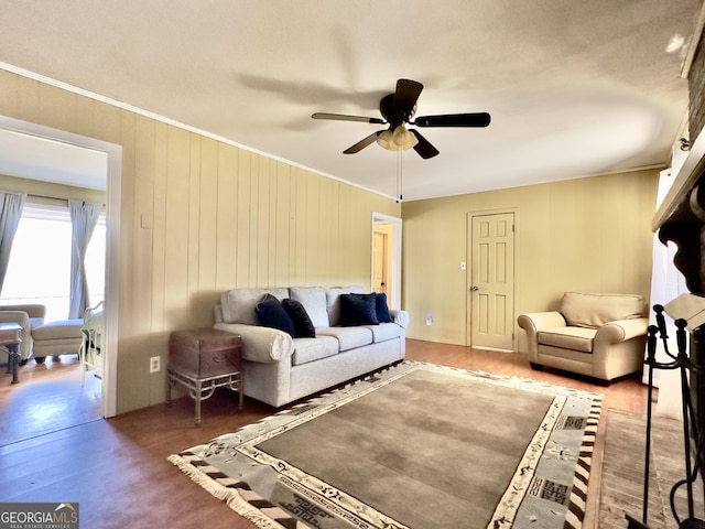 living room featuring dark hardwood / wood-style flooring, ornamental molding, and ceiling fan