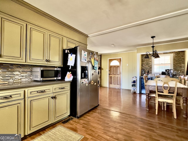 kitchen with a chandelier, stainless steel appliances, light hardwood / wood-style floors, and cream cabinets