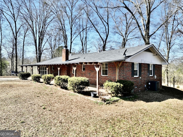 view of property exterior with central AC unit and a lawn