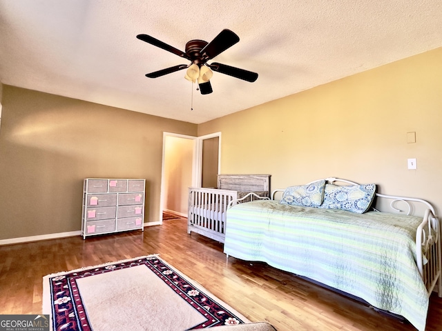 unfurnished bedroom featuring ceiling fan, dark wood-type flooring, and a textured ceiling