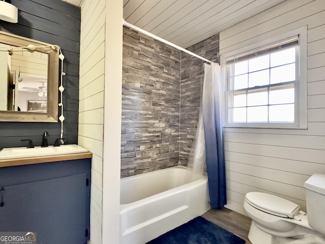 full bathroom featuring shower / bathtub combination with curtain, hardwood / wood-style flooring, wooden walls, vanity, and toilet