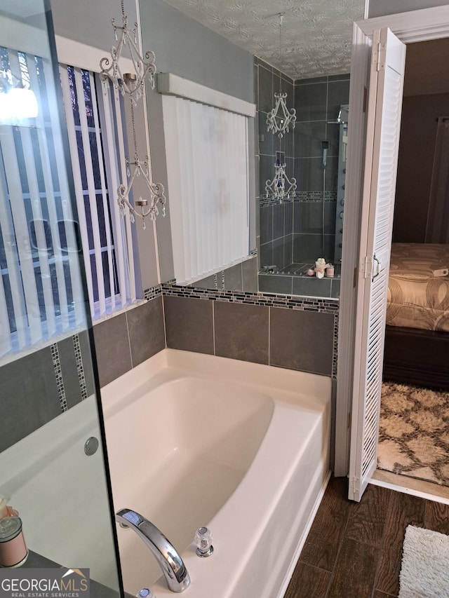 1440 Steam Engine Way NE, Conyers, GA 30013 - ensuite bathroom featuring a garden tub and wood finished floors
