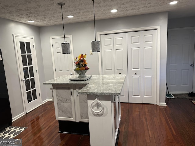 kitchen featuring dark wood-style floors, baseboards, and light stone countertops