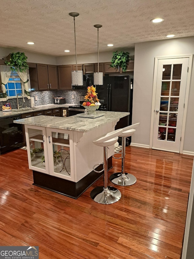 kitchen featuring hardwood / wood-style flooring, black dishwasher, backsplash, and electric range