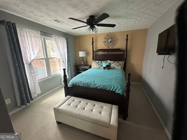 carpeted bedroom featuring a textured ceiling, ceiling fan, visible vents, and baseboards