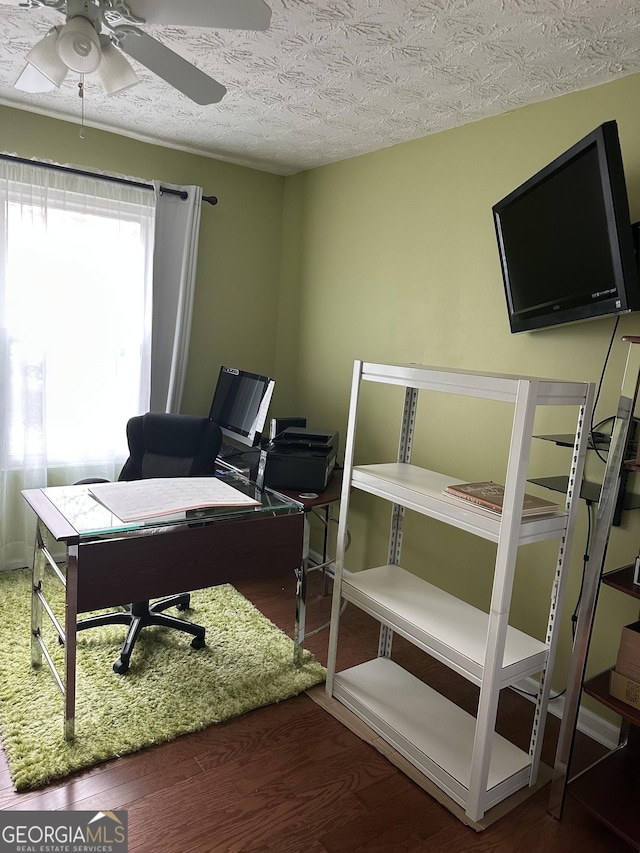 home office with a ceiling fan, a textured ceiling, and wood finished floors