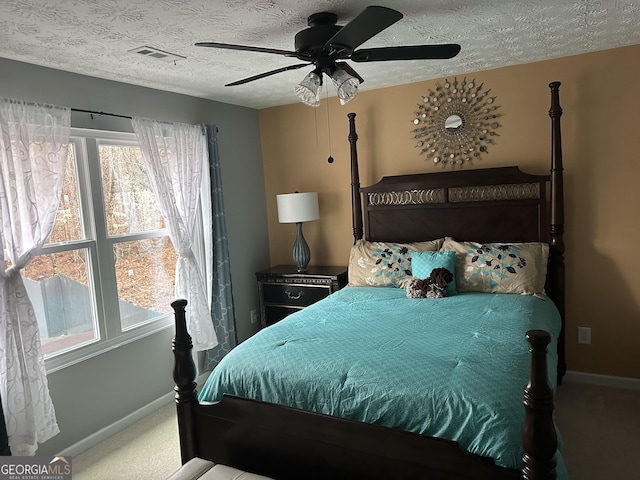 carpeted bedroom with baseboards, visible vents, ceiling fan, and a textured ceiling