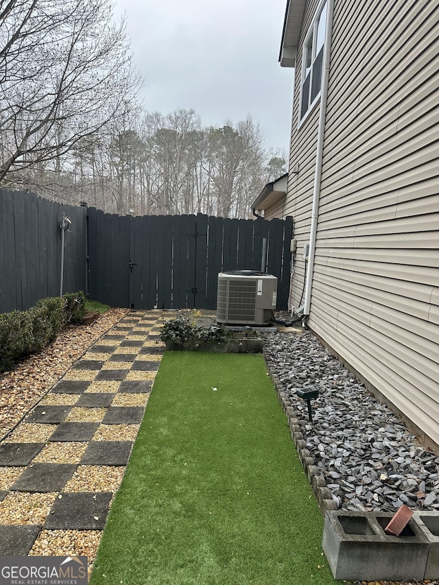 view of yard featuring fence and central AC unit