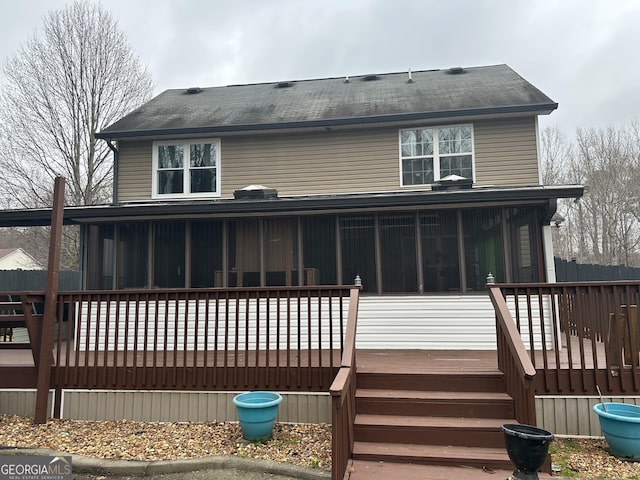 rear view of property with stairs, a wooden deck, and a sunroom