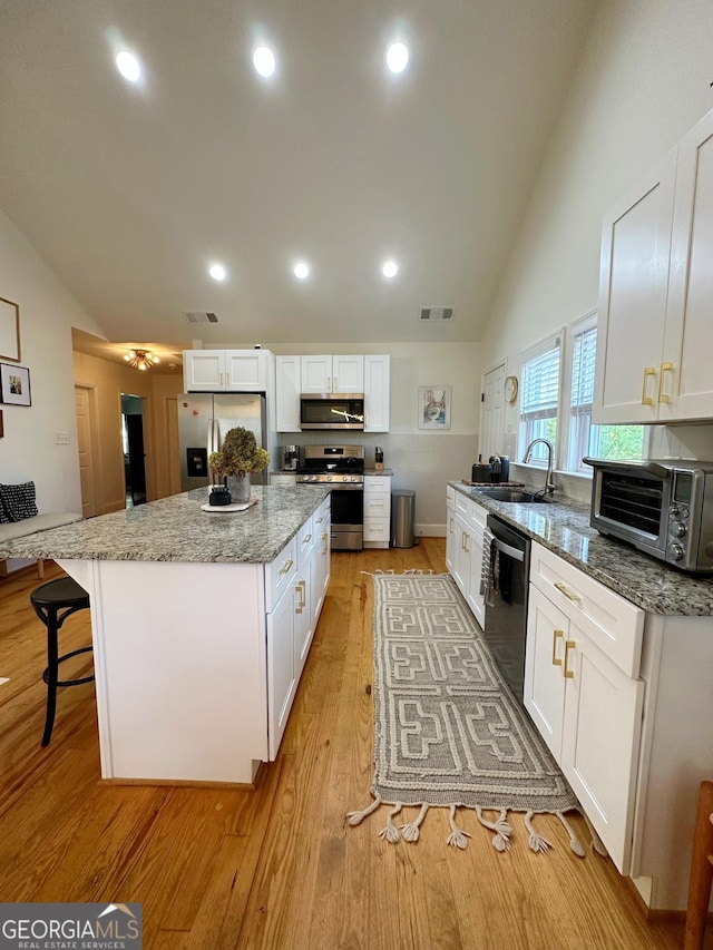 kitchen featuring white cabinetry, appliances with stainless steel finishes, and a kitchen island