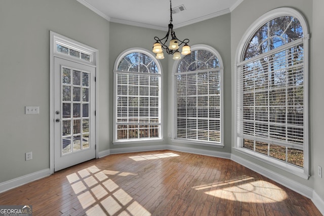 unfurnished dining area with ornamental molding, a notable chandelier, and light hardwood / wood-style flooring