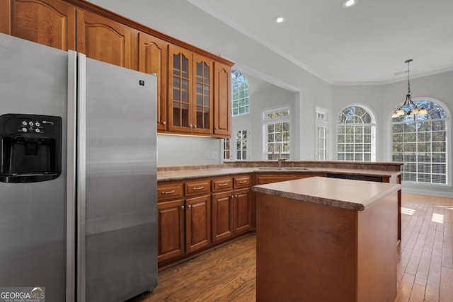 kitchen with sink, ornamental molding, dark hardwood / wood-style flooring, stainless steel fridge with ice dispenser, and decorative light fixtures