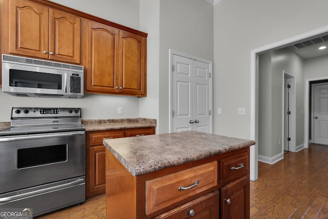 kitchen with stainless steel appliances, dark hardwood / wood-style flooring, and a center island